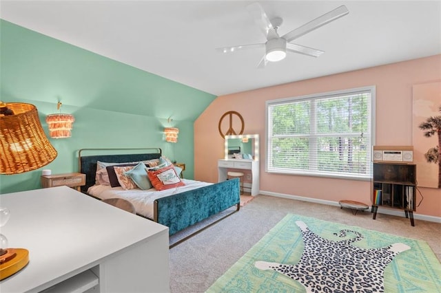 carpeted bedroom featuring vaulted ceiling, baseboards, and ceiling fan