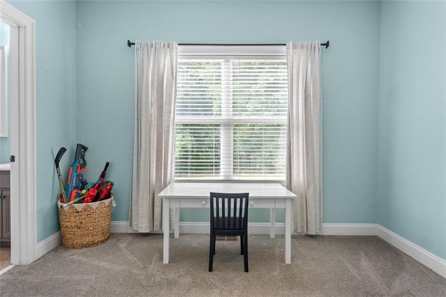 office area featuring a healthy amount of sunlight, baseboards, and carpet