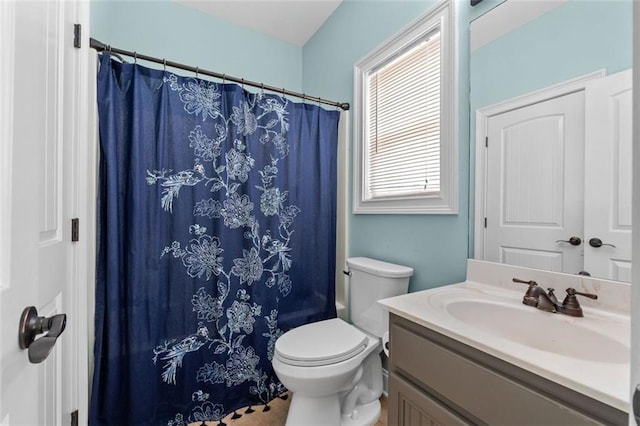 bathroom featuring toilet, vanity, and a shower with curtain