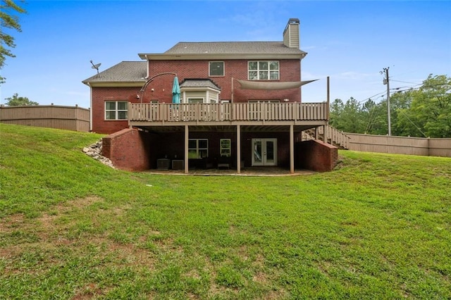 rear view of house featuring brick siding, a deck, french doors, and fence