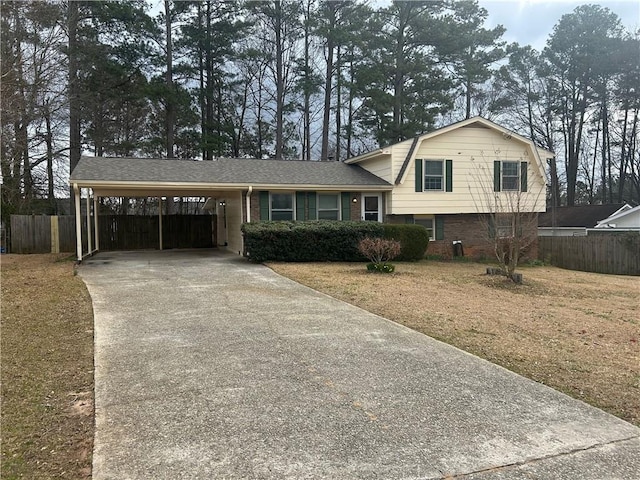 split level home with concrete driveway, brick siding, fence, and a gambrel roof