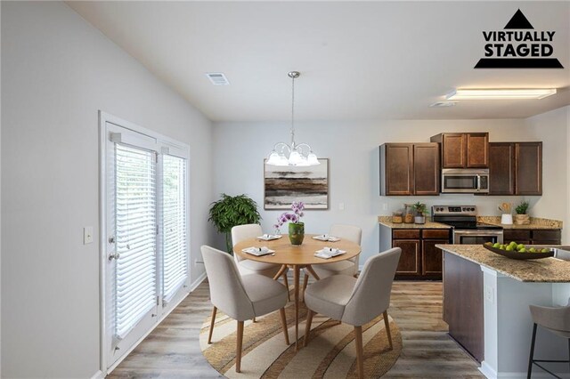 1003 Eldon Ln, Fairburn, GA 30213 - kitchen with appliances with stainless steel finishes, decorative light fixtures, dark brown cabinets, an inviting chandelier, and light wood-type flooring