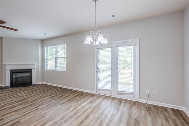 1003 Eldon Ln, Fairburn, GA 30213 - unfurnished living room featuring baseboards, a glass covered fireplace, visible vents, and wood finished floors