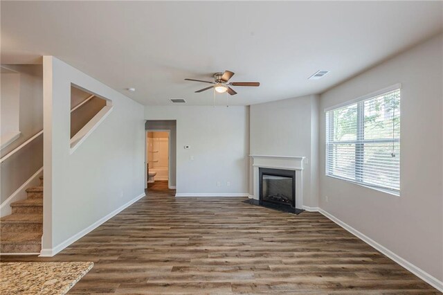 1003 Eldon Ln, Fairburn, GA 30213 - unfurnished living room with a ceiling fan, visible vents, stairs, wood finished floors, and a fireplace