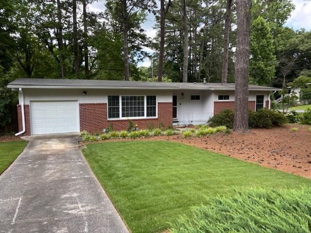 1177 Baker Ln, Marietta, GA 30062 - single story home with a garage, brick siding, driveway, a front yard, and view of scattered trees
