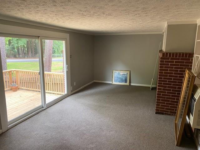 1177 Baker Ln, Marietta, GA 30062 - unfurnished living room featuring carpet flooring, a textured ceiling, baseboards, and crown molding