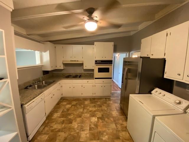 1177 Baker Ln, Marietta, GA 30062 - kitchen with white appliances, under cabinet range hood, washing machine and dryer, ceiling fan, and white cabinets