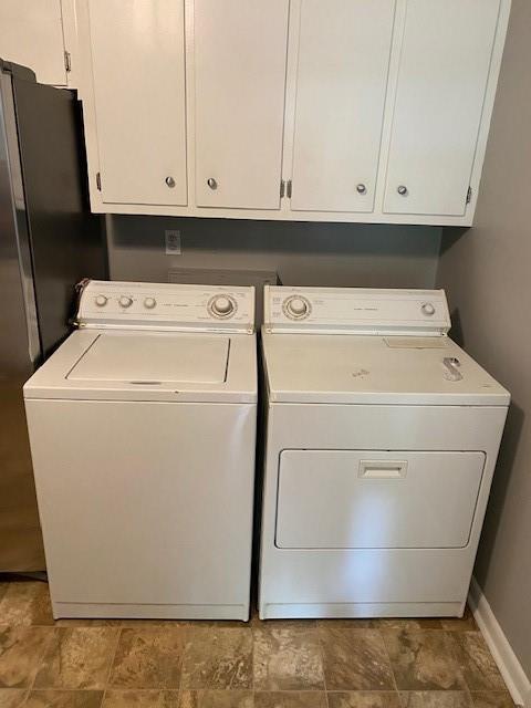 1177 Baker Ln, Marietta, GA 30062 - laundry room featuring washer and dryer, stone finish flooring, and baseboards