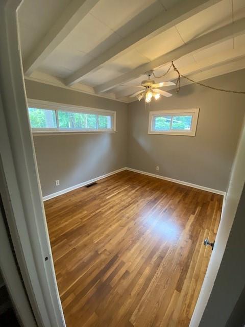 1177 Baker Ln, Marietta, GA 30062 - spare room featuring beam ceiling, baseboards, wood finished floors, and ceiling fan