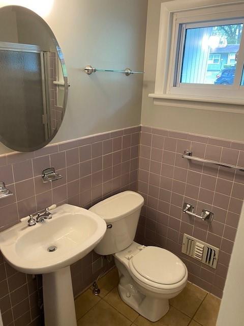 1177 Baker Ln, Marietta, GA 30062 - bathroom featuring tile walls, tile patterned flooring, toilet, wainscoting, and an enclosed shower