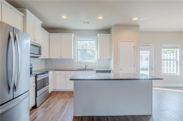 235 Orchard Dr, Covington, GA 30014 - kitchen with appliances with stainless steel finishes, light wood-style floors, stone countertops, plenty of natural light, and recessed lighting