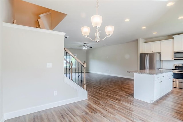 235 Orchard Dr, Covington, GA 30014 - kitchen featuring appliances with stainless steel finishes, a ceiling fan, a chandelier, a center island, and recessed lighting