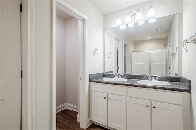 235 Orchard Dr, Covington, GA 30014 - full bathroom with double vanity, a stall shower, and wood finished floors