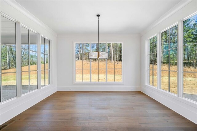 unfurnished dining area with visible vents, ornamental molding, dark wood-type flooring, and a healthy amount of sunlight