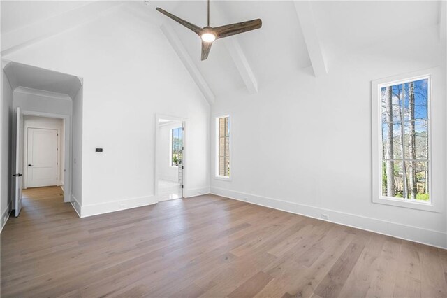 unfurnished room featuring baseboards, beamed ceiling, high vaulted ceiling, and wood finished floors