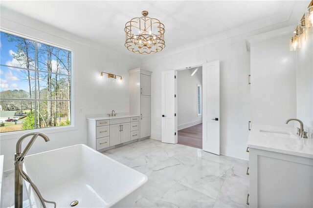 bathroom with a freestanding tub, a sink, two vanities, marble finish floor, and ornamental molding