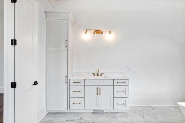 bathroom with baseboards, marble finish floor, and vanity