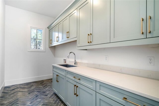 kitchen with baseboards, light countertops, and a sink