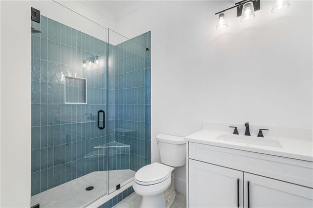 bathroom featuring toilet, vanity, and a stall shower