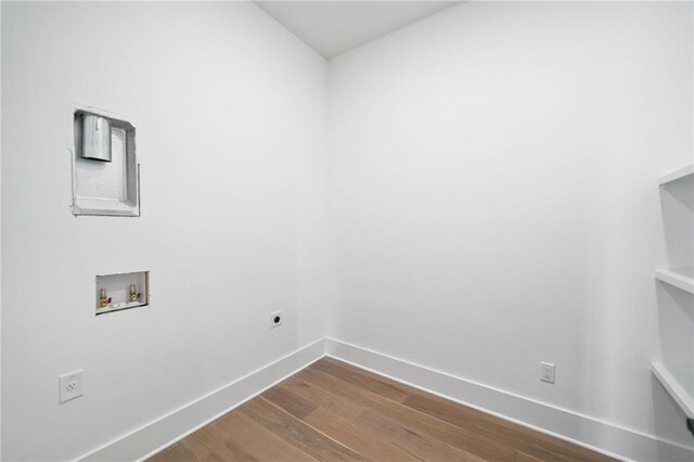 interior space with hookup for a washing machine, baseboards, laundry area, electric dryer hookup, and dark wood-style floors