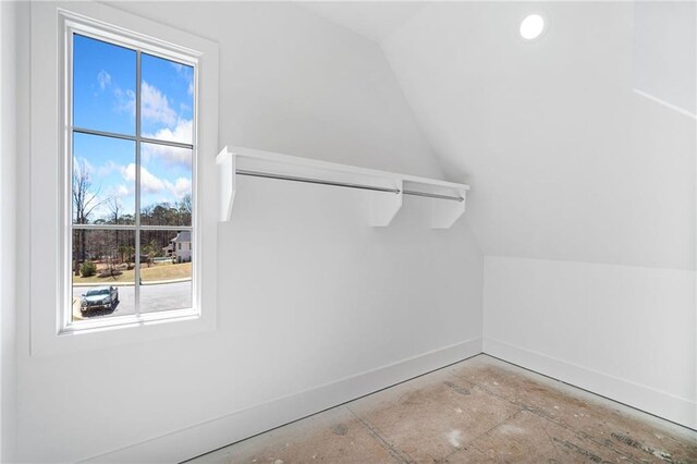 interior space featuring plenty of natural light, baseboards, and lofted ceiling