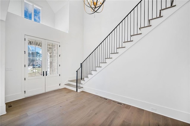 entrance foyer with visible vents, baseboards, stairway, and wood finished floors