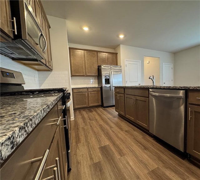 2277 Whitworth St, Lawrenceville, GA 30044 - kitchen featuring appliances with stainless steel finishes, dark wood-style flooring, dark stone countertops, tasteful backsplash, and recessed lighting