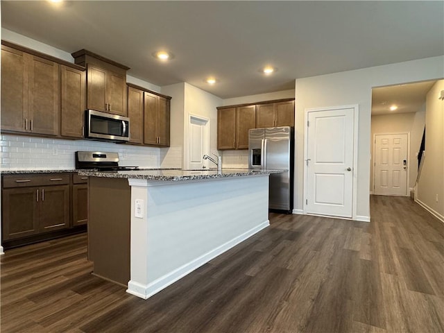 2277 Whitworth St, Lawrenceville, GA 30044 - kitchen featuring stainless steel appliances, dark wood finished floors, decorative backsplash, a kitchen island with sink, and recessed lighting