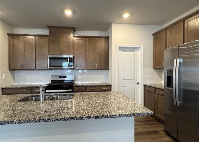 2277 Whitworth St, Lawrenceville, GA 30044 - kitchen featuring stainless steel appliances, a sink, dark stone countertops, dark wood-type flooring, and tasteful backsplash