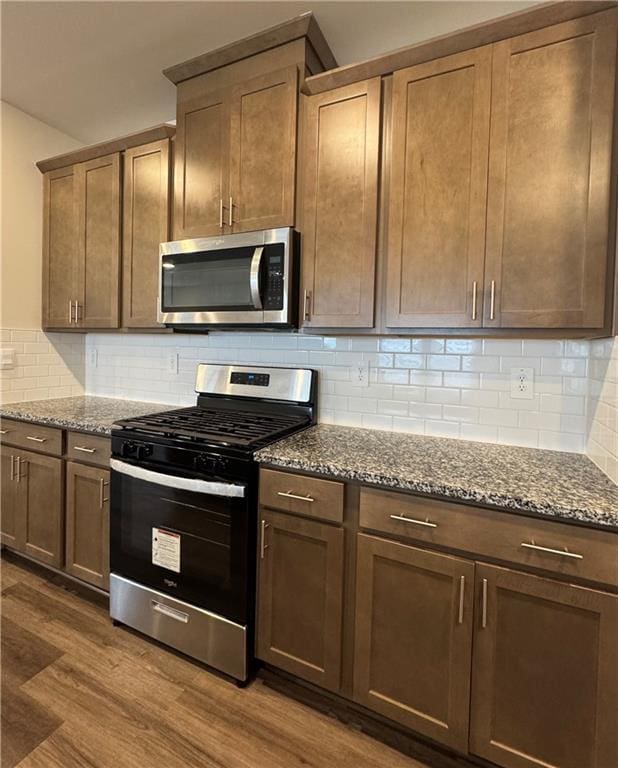 2277 Whitworth St, Lawrenceville, GA 30044 - kitchen with stainless steel appliances, dark wood-type flooring, dark stone countertops, and tasteful backsplash