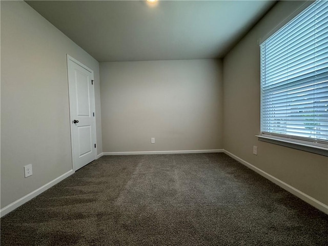 2277 Whitworth St, Lawrenceville, GA 30044 - empty room featuring dark carpet, baseboards, and healthy amount of natural light