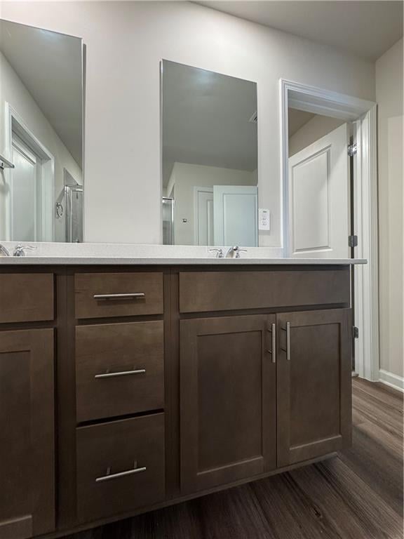 2277 Whitworth St, Lawrenceville, GA 30044 - bathroom with double vanity, wood finished floors, and baseboards