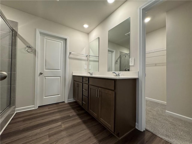 2277 Whitworth St, Lawrenceville, GA 30044 - bathroom with a stall shower, a spacious closet, wood finished floors, double vanity, and baseboards