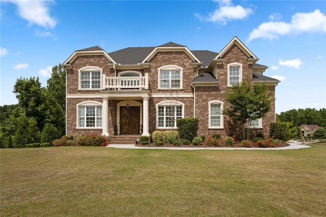 view of front of property featuring a front yard and a balcony