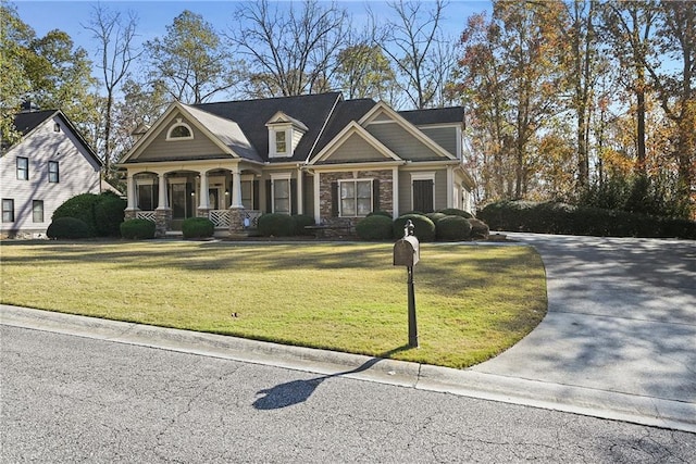 403 Pebblebrooke Ln, Canton, GA 30115 - craftsman-style house with covered porch, a front yard, driveway, and stone siding