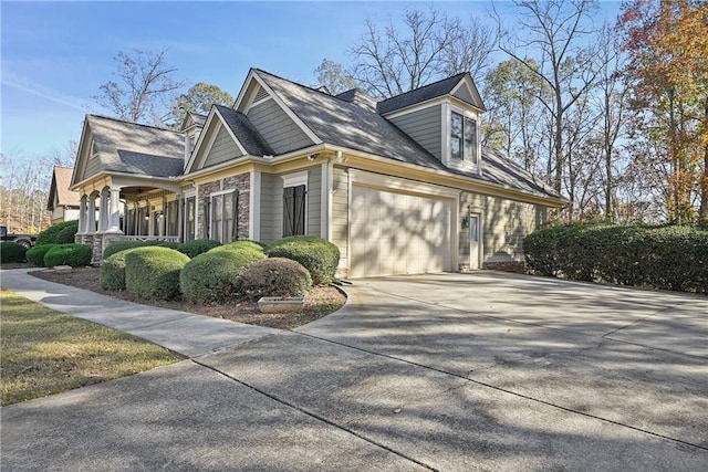 403 Pebblebrooke Ln, Canton, GA 30115 - view of side of home featuring a garage, concrete driveway, stone siding, a porch, and roof with shingles