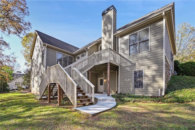 rear view of house featuring a lawn and a deck