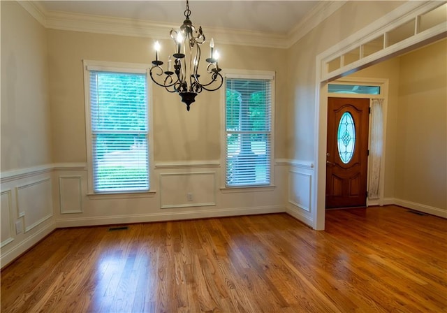 403 Pebblebrooke Ln, Canton, GA 30115 - foyer featuring a chandelier, wood finished floors, crown molding, wainscoting, and a decorative wall