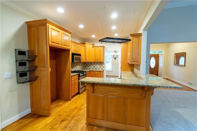 403 Pebblebrooke Ln, Canton, GA 30115 - kitchen featuring appliances with stainless steel finishes, ornamental molding, a peninsula, light stone counters, and backsplash