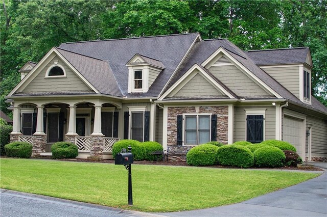 403 Pebblebrooke Ln, Canton, GA 30115 - craftsman house with covered porch, stone siding, a front lawn, a shingled roof, and driveway