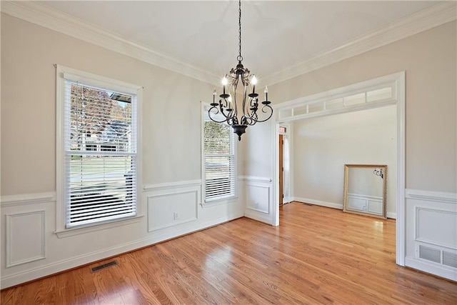 403 Pebblebrooke Ln, Canton, GA 30115 - unfurnished dining area with a chandelier, crown molding, light wood-type flooring, wainscoting, and a decorative wall