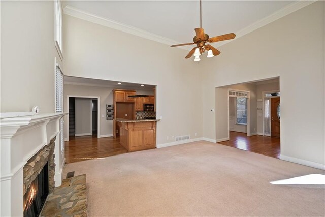403 Pebblebrooke Ln, Canton, GA 30115 - unfurnished living room featuring light colored carpet, ornamental molding, baseboards, a fireplace, and ceiling fan