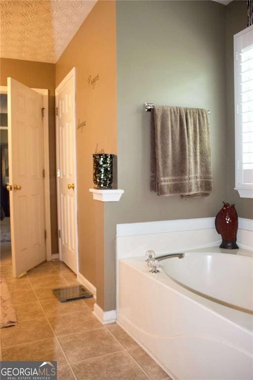 978 Francis Ln, Fairburn, GA 30213 - bathroom with a garden tub, tile patterned flooring, and a textured ceiling