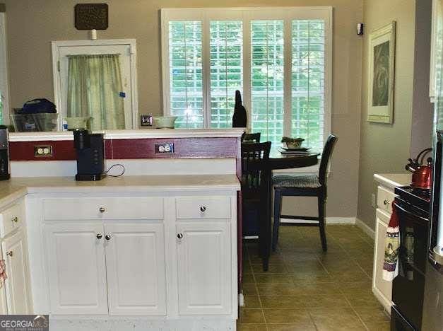 978 Francis Ln, Fairburn, GA 30213 - kitchen featuring light tile patterned flooring, white cabinetry, and light countertops