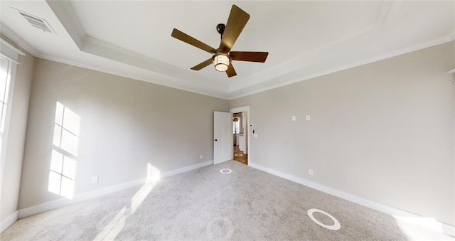 spare room with carpet floors, a raised ceiling, ceiling fan, and ornamental molding