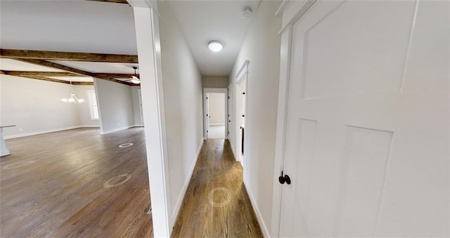 hallway with beam ceiling, a chandelier, and dark wood-type flooring