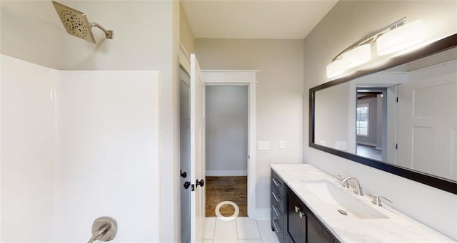 bathroom with tile patterned flooring, vanity, and walk in shower