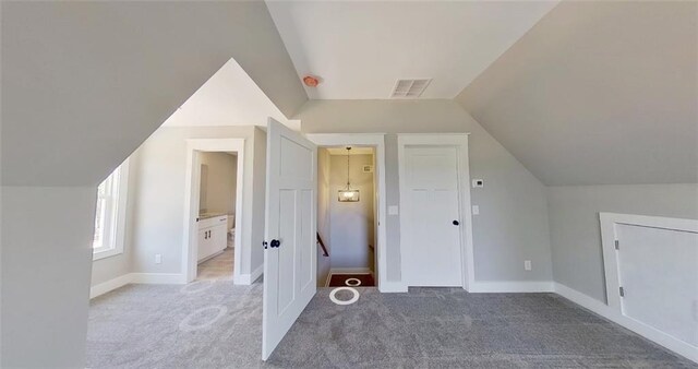 additional living space with carpet floors and vaulted ceiling