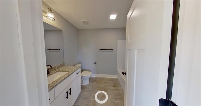 bathroom featuring a tub, vanity, and toilet