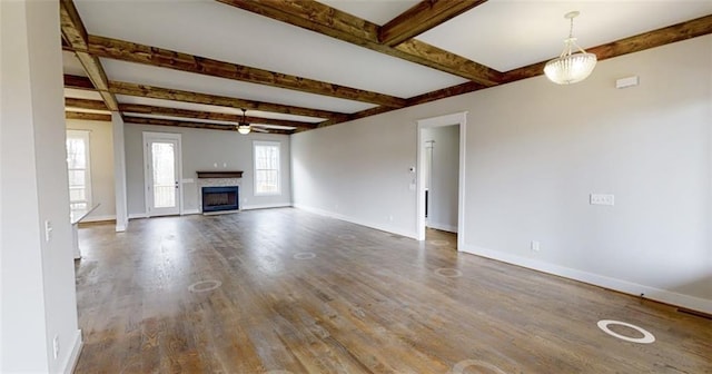 unfurnished living room with beamed ceiling, hardwood / wood-style flooring, and ceiling fan